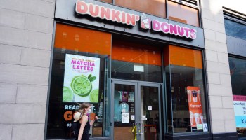 A person in a protective mask walks by a temporarily closed Dunkin' Donuts as New York City moves into Phase 3 of reopening following restrictions imposed to curb the coronavirus pandemic on July 13, 2020.