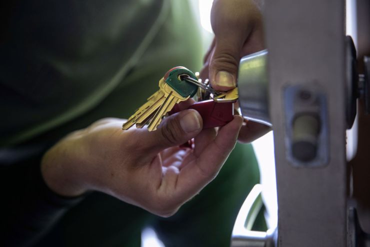 A maintenance worker changes the lock of an apartment