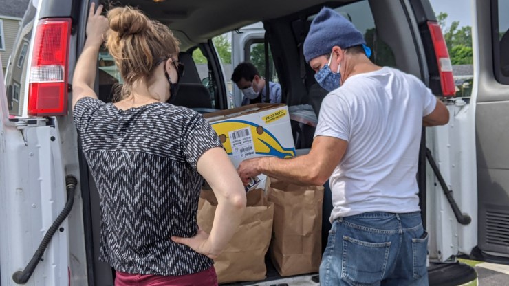 A team from the Landing Place, an organization for at-risk youth, prepares bags of food and other supplies for families in Maine's midcoast region.