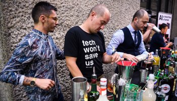 A bartender wearing a shirt that reads "tech won't save us, join a union" makes drinks at an event promoting AI in London last year.