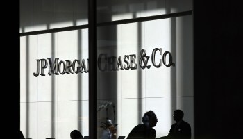 People pass a sign for JPMorgan Chase & Co. at it's headquarters in Manhattan.