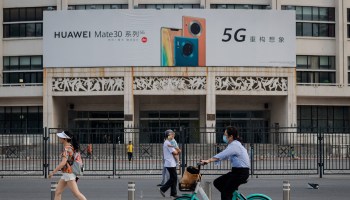 People pass by a billboard advertising Huawei's new 5G smartphones in Beijing.