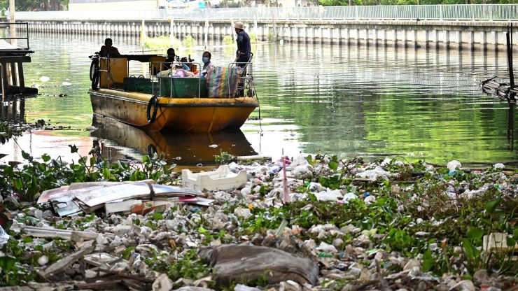 Municipal workers clearing plastic from a canal in Bangkok in June.