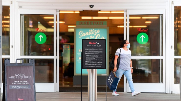 A shopper steps out of the Westfield Santa Anita shopping mall in Arcadia, California, on October 7, 2020, the first day LA County shopping malls have been allowed to reopen, at 25% maximum capacity, after months of closure due to the coronavirus pandemic.