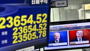 A screen displays Tokyo Stock Exchange share prices as a news channel features portraits of U.S. presidential candidates Donald Trump (right) and Joe Biden at a foreign exchange trading company in Tokyo on November 4, 2020, as Asian markets react to early predictions.