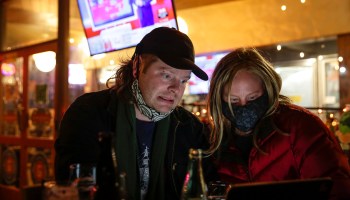 A couple anxiously monitors election results on a laptop during an election night event at The Growler Guys in Seattle, Washington on November 3, 2020.