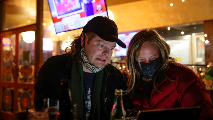 A couple anxiously monitors election results on a laptop during an election night event at The Growler Guys in Seattle, Washington on November 3, 2020.