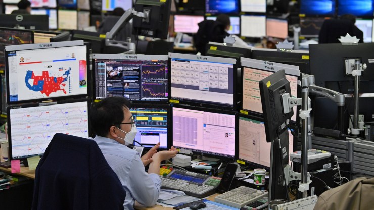 Currency dealers monitor exchange rates in a trading room at KEB Hana Bank in Seoul on November 4, 2020, as Asian markets react to early predictions following the U.S. presidential election.