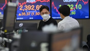 Currency dealers monitor exchange rates as screens show South Korea's benchmark stock index (left) and the Korean won/USD exchange rate (right) in a trading room at KEB Hana Bank in Seoul on November 5, 2020.
