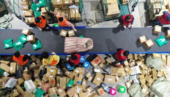 Workers sort packages for delivery at a warehouse of China Post Group in Hengyang, in central China's Hunan province on November 12, 2020, a day after the end of the Singles' Day shopping festival.