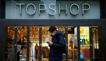 A pedestrian wearing a face covering due to the COVID-19 pandemic walks past a temporarily closed-down Topshop clothes store, operated by Arcadia, in central London on November 30, 2020.