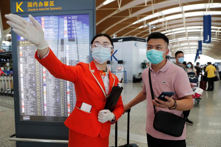 A worker guides a passenger at Pudong International Airport on September 28, 2020 in Shanghai, China.