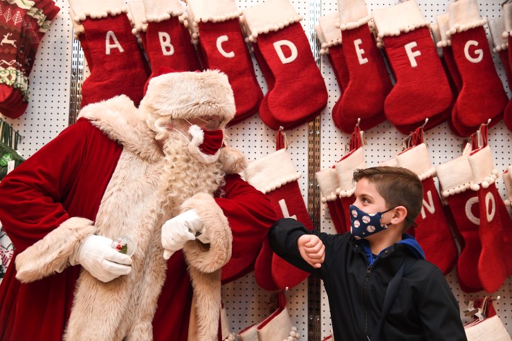 Santa Claus greets a child with an elbow bump at a Selfridges store in London.