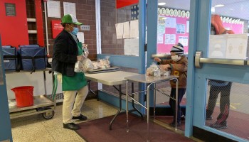 A student chaperoned by an adult picks up a meal to go on November 19, 2020 at Yung Wing School P.S. 124 in New York City.