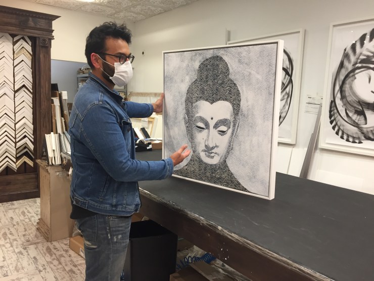 Jawed Farooqi examines a painting at one of Rooq's locations.