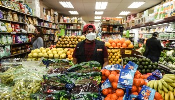 A bodega worker restocks produce in Brooklyn earlier this year.