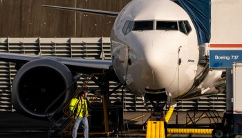 A worker walks by a Boeing 737 Max airplane as it sits parked at the company's production facility on Nov. 13 in Renton, Washington.