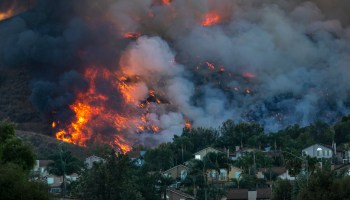 Flames rise near homes during the Blue Ridge Fire on October 27, 2020 in Chino Hills, California.