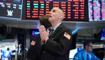 A trader clasps his hands and looks up on the floor of the New York Stock Exchange on March 18.