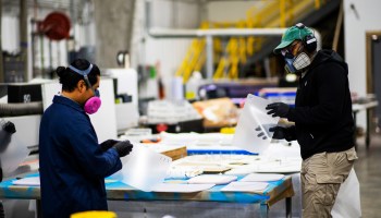 Workers manufacture face shields in New York. Demand is healthy for medical and cleaning supplies.