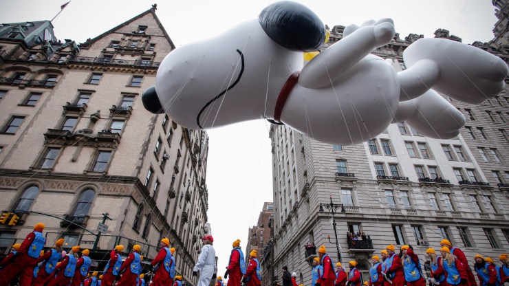 The Snoopy balloon floats down Central Park West during the 2014 Macy's Thanksgiving Day Parade.