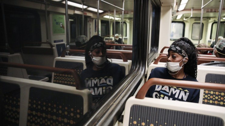 A woman wears a face mask while riding a Metro Rail train in April in Los Angeles.