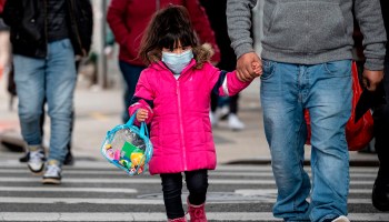 A girl, wearing a mask, walks down a street in the Corona neighborhood of Queens on April 14, 2020 in New York City.