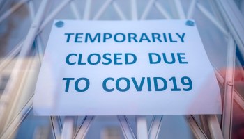 A sign is seen in the window of a shop explaining to customers that it has temporarily closed due to the coronavirus outbreak in Portobello Market in west London on June 1, 2020.