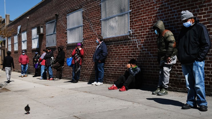 People wait in line to receive food at a food bank on April 28, 2020 in the Brooklyn borough of New York City.