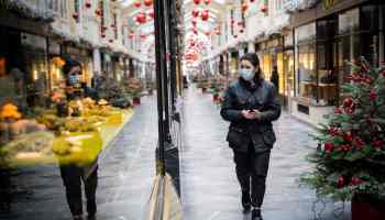A pedestrian wearing a face mask due to the COVID-19 pandemic, walks past Christmas-themed window displays inside Burlington Arcade in central London, on November 23, 2020.