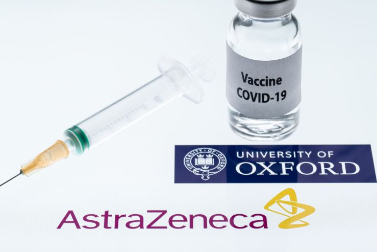 This illustration picture shows a syringe and a bottle reading "Covid-19 Vaccine" next to AstraZeneca company and University of Oxford logos.