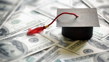 In this photo illustration, a college graduation cap sits on top of a pile of $100 bills.