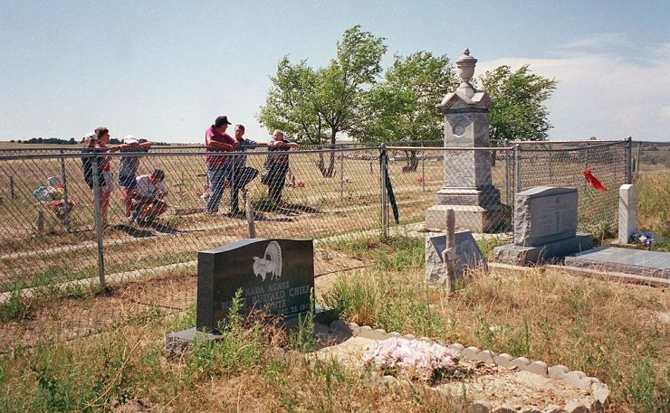 WOUNDED KNEE, SD - AUGUST 1: This August, 2001 photo shows tourists visiting the burial site of Lakota Native Americans killed in the 29 December 1890 massacre by US Army soldiers at Wounded Knee in South Dakota. Wounded Knee is part of the Pine Ridge Indian Reservation in the Badlands National Park. Some 300 Lakota people were reported killed. (Photo credit should read FRANCIS TEMMAN/AFP via Getty Images)