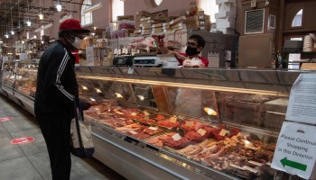 A man purchases meat at Eastern Market in Washington, D.C., in May.