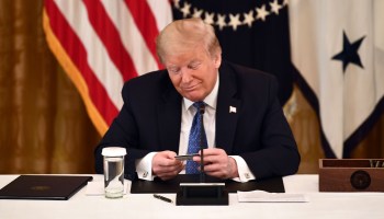President Donald Trump admires a pre-paid stimulus debit card during a meeting with his cabinet in May in Washington, D.C.