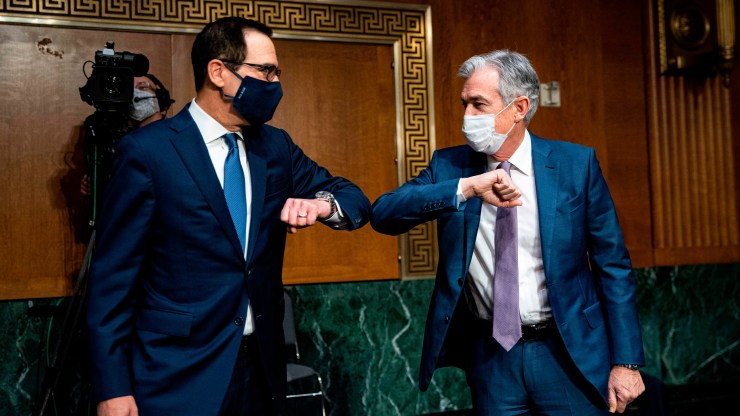 Treasury Secretary Steven Mnuchin and Federal Reserve Chair Jerome Powell greet each other with an elbow bump as they arrive at Tuesday's Senate Banking Committee hearing.
