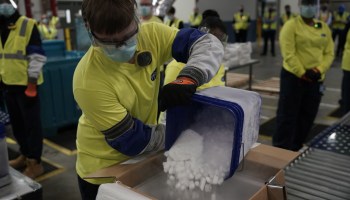 A worker pours dry ice into boxes containing the Pfizer-BioNTech COVID-19 vaccine as they are prepared to be shipped in Kalamazoo, Michigan, on Dec. 13, 2020.