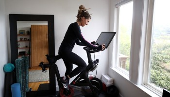 A woman rides her Peloton at home in California in April.