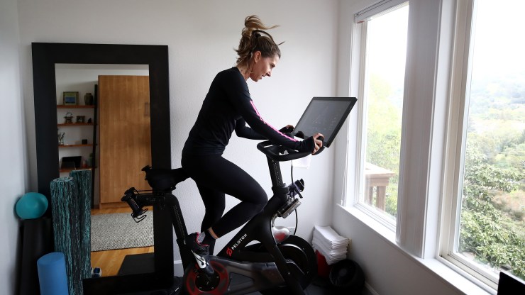 A woman rides her Peloton at home in California in April.
