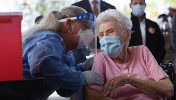 An 88-year-old nursing home resident in Florida prepares to receive the Pfizer-BioNTech vaccine.