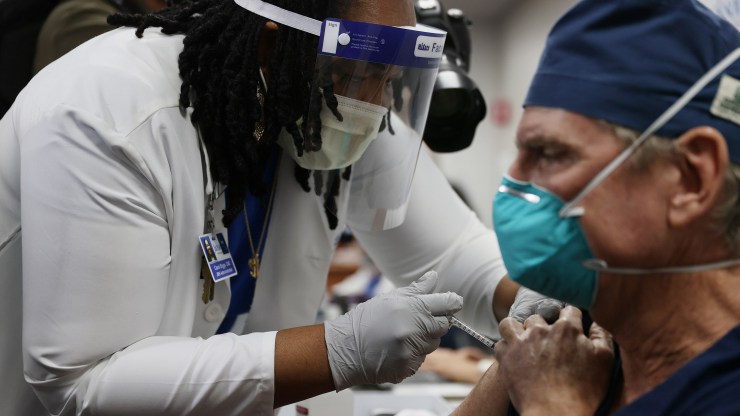 A medical worker administers the Pfizer BioNtech COVID-19 vaccine to a doctor at a hospital in Miami on Dec. 15.