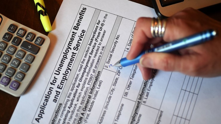 In this photo illustration, a person files an application for unemployment benefits on April 16, 2020, in Arlington, Virginia.