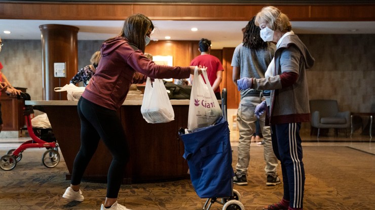 After shopping for groceries, a volunteer provides a no-contact delivery for seniors at a residential complex on April 17, 2020 in North Bethesda, Maryland.