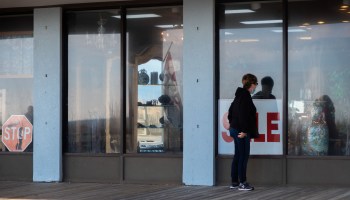 A woman peers into a boardwalk store advertising a sale on January 2, 2021 in Rehoboth Beach, Delaware.