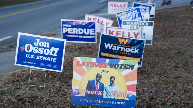 Campaign signs for both Democratic and Republican candidates in the Georgia Senate runoff elections line a road at a Gwinnett County voting location on January 5, 2021 in Atlanta, Georgia.