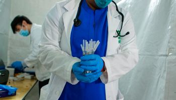 A health worker carries syringes to administer Pfizer Covid-19 vaccines at the opening of a new vaccination site at Corsi Houses in Harlem, New York, on Jan. 15, 2021.