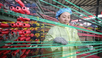 An employee works on the production line of a plastic knitting enterprise in Lianyungang, East China's Jiangsu Province, Jan 18, 2021.
