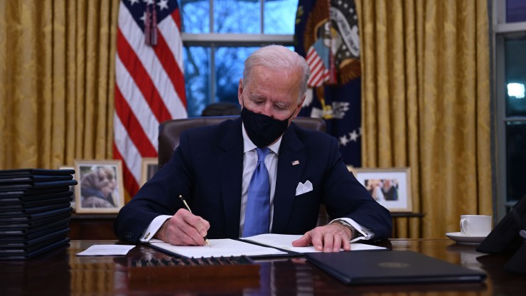 President Joe Biden sits in the Oval Office as he signs a series of orders at the White House in Washington after being sworn in at the U.S. Capitol on January 20, 2021.