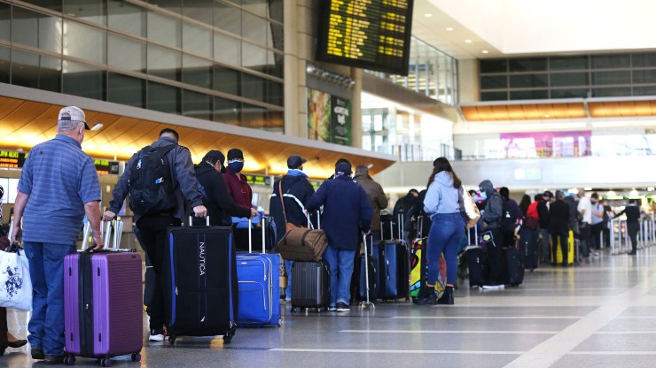 Travelers wait in line to check in for a flight at the Tom Bradley International Terminal at Los Angeles International Airport (LAX) amid a COVID-19 surge in Southern California on December 22, 2020 in Los Angeles, California.