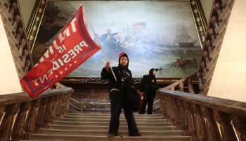 An extremist holds a Trump flag inside the U.S. Capitol near the Senate chamber on Jan. 6.